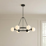 Castell 6 Globe Round Chandelier 36", Matte Black globe Chandelier in a Transitional Dining Room with wall paneling and a grid window.