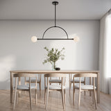 Milo 2 Globe Linear Arc LED Pendant, Matte Black with white opal glass, shown above a light wood table with six chairs in aa scandi dining room