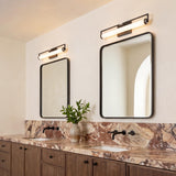 A modern bathroom with two Ian LED Vanity Lights in matte black and chrome finishes mounted over rectangular mirrors above a brown marble countertop.