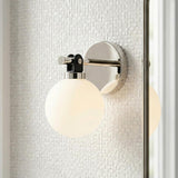 Bryce Polished Nickel globe Wall Sconce in a Contemporary Bathroom with white mosaic tile.