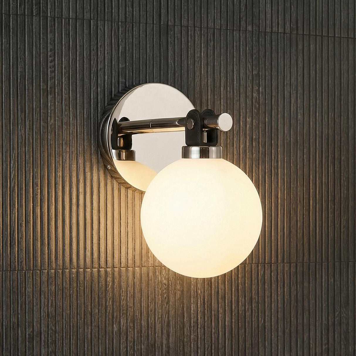 Bryce Vanity Wall Sconce, Polished Nickel globe Wall Sconce in a Modern Bathroom with a dark fluted wall.