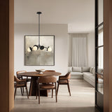 Levi pendant in black, shown in a modern dining room witha  wooden table and chairs, light gray sofa, and abstract art on the wall.