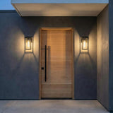 Colin Outdoor Wall Light, Small Matte Black geometric Outdoor Wall in a Modern Outdoor with a light wood door and concrete walls.