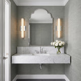 A transitional bathroom with two Ronan 18" Opal Glass LED Vanity Lights in chrome flanking an arched mirror above a white marble floating vanity and gray grasscloth wallpaper.