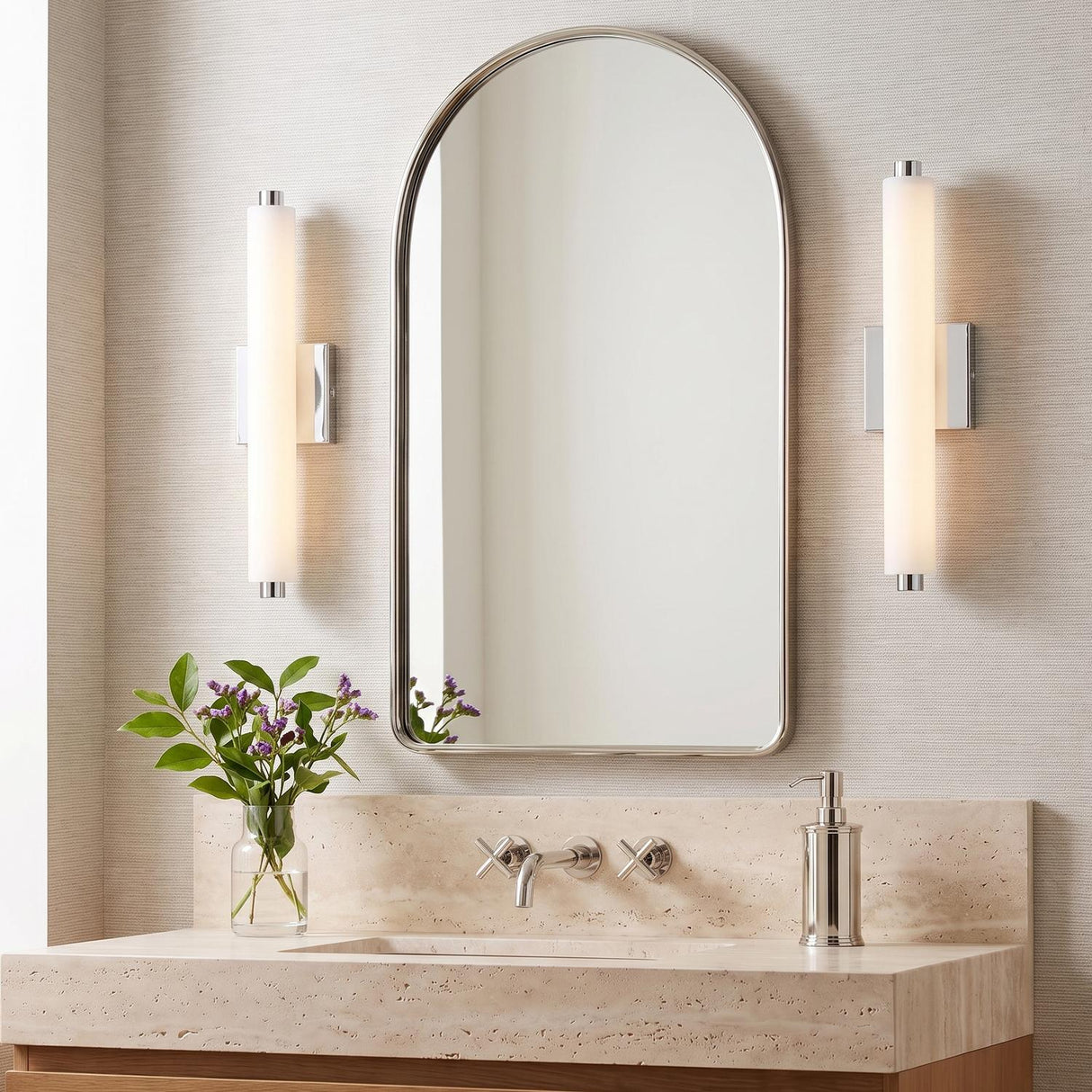 A contemporary bathroom with two Ronan 18" Opal Glass LED Vanity Lights in chrome flanking an arched mirror above a travertine vanity and textured wallpaper.