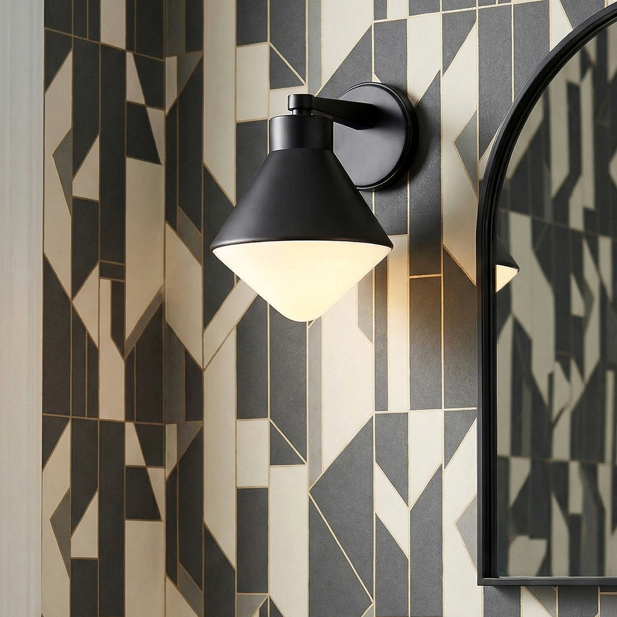 Andie Wall Sconce, Matte Black geometric Wall Sconce in a Modern Bathroom with geometric wallpaper and an arched mirror.