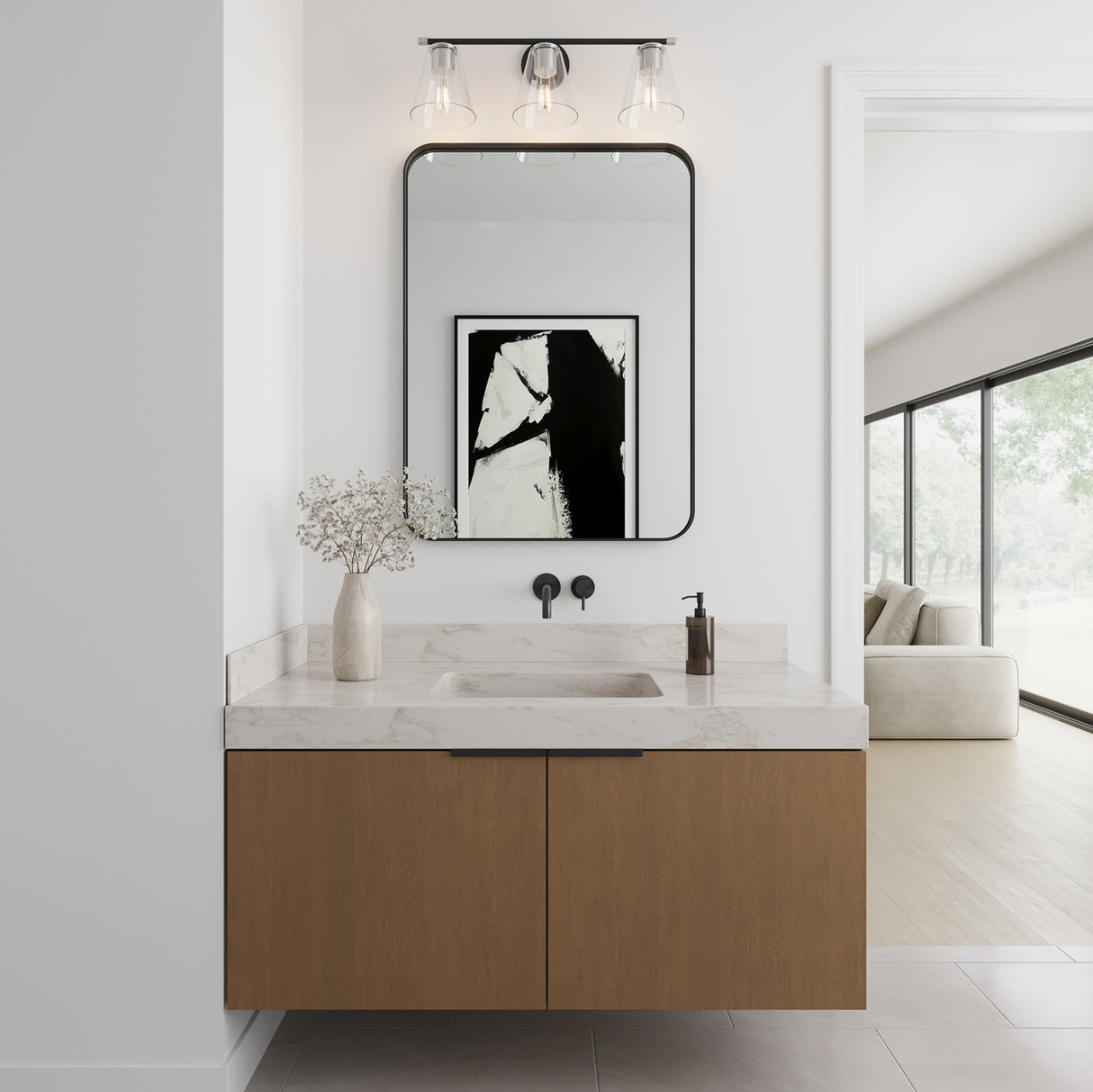 Carlisle 3 Light 24" Vanity, Matte Black and Chrome Finish, Clear Tapered Glass Shades, shown above a single modern floating vanity, with natural stone, wood, and black details.