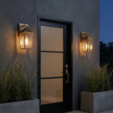Cole Outdoor Wall Light, Small 13" Burnished Brass geometric Outdoor Wall Light in a Transitional Outdoor with dark textured wall & concrete planters.
