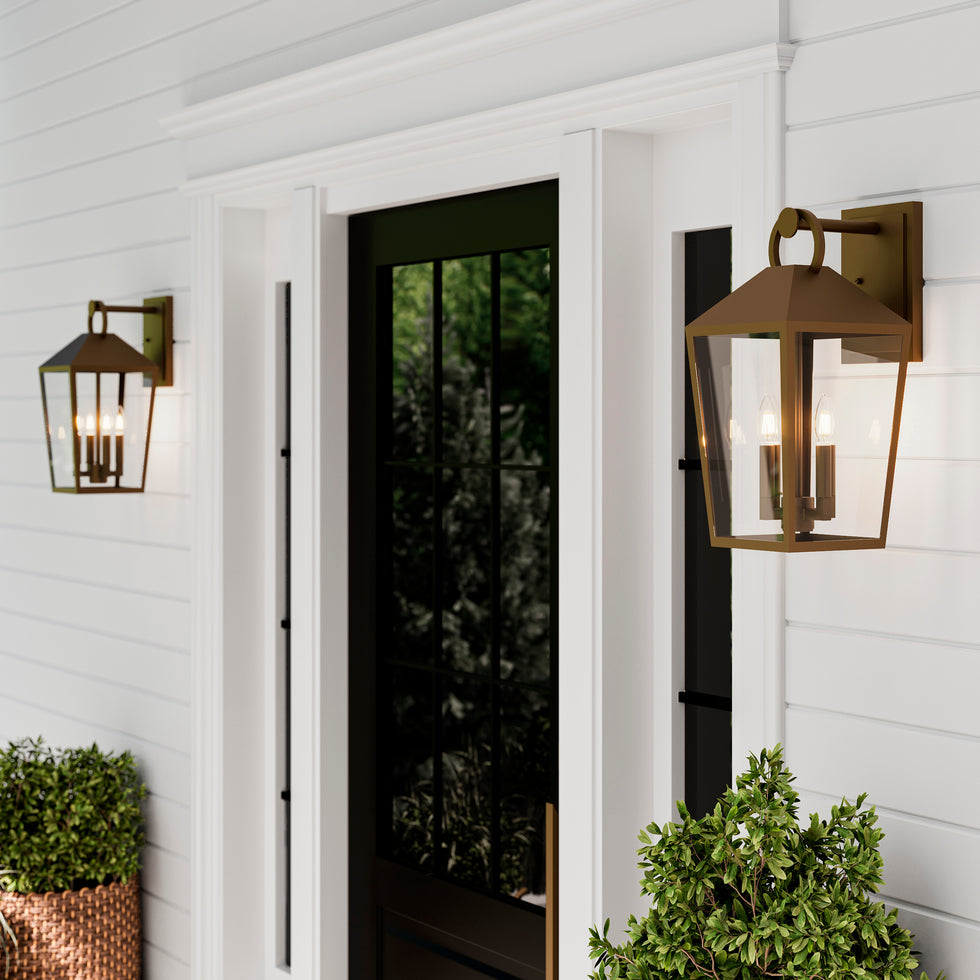 Cole Wall Light in Burnished Brass flanking a front door under a covered porch at spring time.