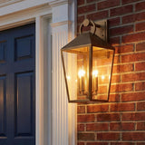 Cole Outdoor Wall Light, Large 21.5" Burnished Brass geometric Outdoor Wall in a Traditional Outdoor with a red brick wall and blue door.