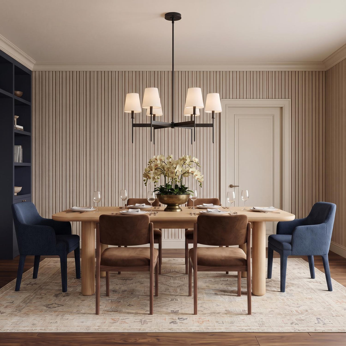 A transitional dining room features the Taylor 6 Light Chandelier in matte black with white linen shades over a light wood table and vertically striped wallpaper.
