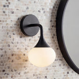 Talia Matte Black globe wall sconce in a Modern Bathroom with a mosaic tile wall and round black mirror.