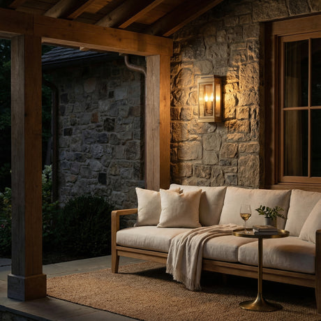 Brighton Outdoor Wall Light, Burnished Brass geometric Outdoor Wall Light in a Cottage Outdoor with a stone wall and cream sofa.