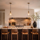 A modern farmhouse kitchen with two Nora Glass Pendants 16" featuring jute rope accents and brass hardware suspended over a marble island with walnut woven barstools.