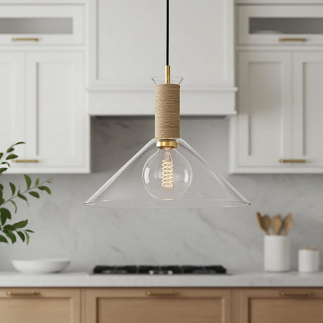 A farmhouse kitchen features a Nora Glass Pendant 16-inch, Medium with clear glass, brushed brass hardware, and woven jute over a marble counter with white shaker cabinets.