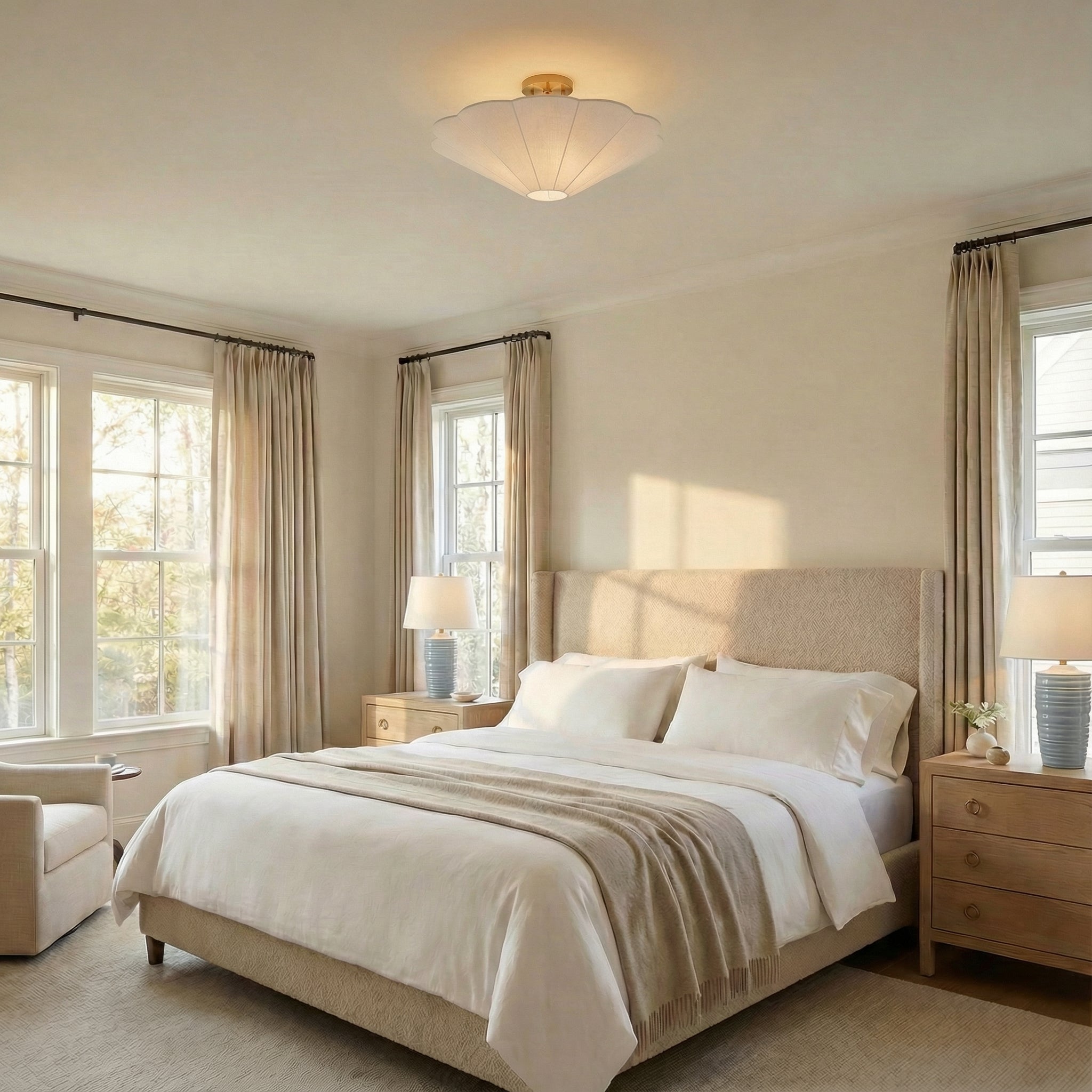 White linen and Brass scalloped semi-flush mount in a Transitional Bedroom with an upholstered bed and wood nightstands.