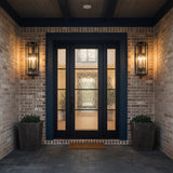 Everett Outdoor Wall Light, Large, Forged Iron Black - Two black lanterns flanking a black double door on a brick exterior