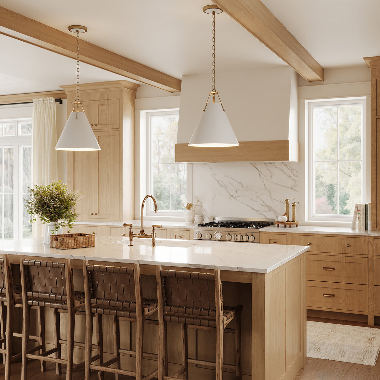 Two Bowie Medium 16" Metal Pendant Lights in White and Brass hung above a kitchen island with white stone countertops and exposed wooden beams