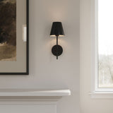 Close-up of Black Banks Wall sconce next to a piece of art against a white wall
