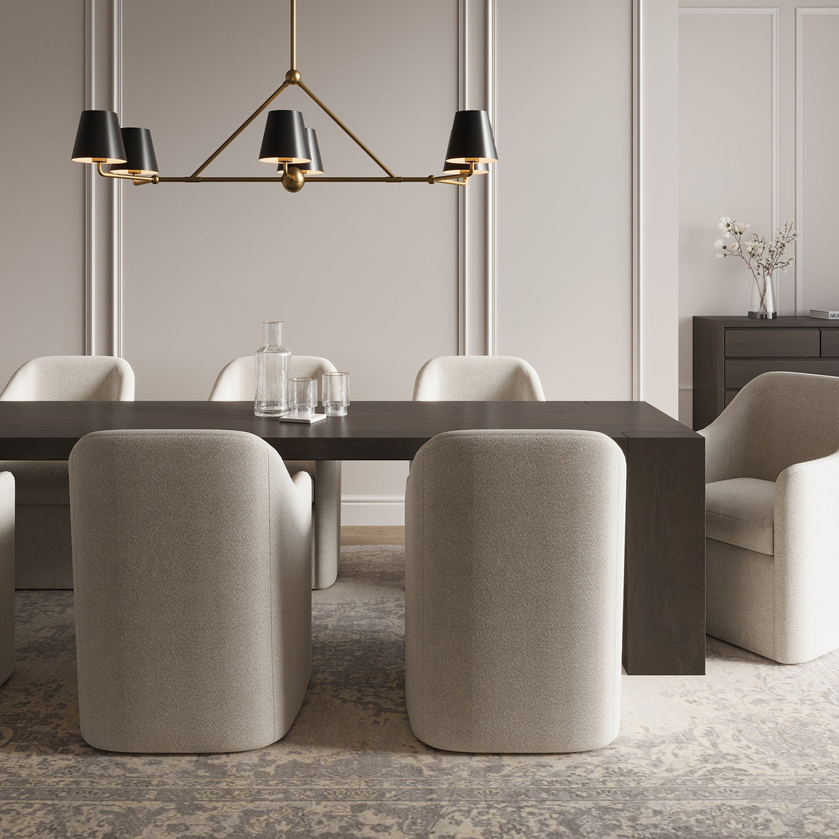 Banks Metal Linear Chandelier, with 6 lights and 46" wide, shown in Matte Black and Brass, is hung over a contemporary dark wood dining table, with seating for eight. 