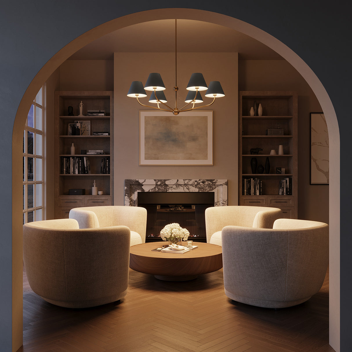 Shown at night, the Banks French Blue Chandelier, with brass accents, 40" wide and with six conical shades, is hung in a contemporary living room with an arched entry, seating area with cream swivel chairs, and herringbone wood floors. 