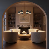 Shown at night, the Banks French Blue Chandelier, with brass accents, 40" wide and with six conical shades, is hung in a contemporary living room with an arched entry, seating area with cream swivel chairs, and herringbone wood floors. 