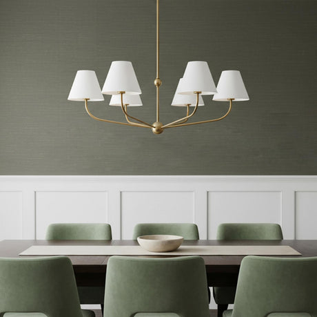 Banks 6 Light Chandelier 40, White and Brass - A brass chandelier with white shades hangs over a dark wood dining table with green chairs.
