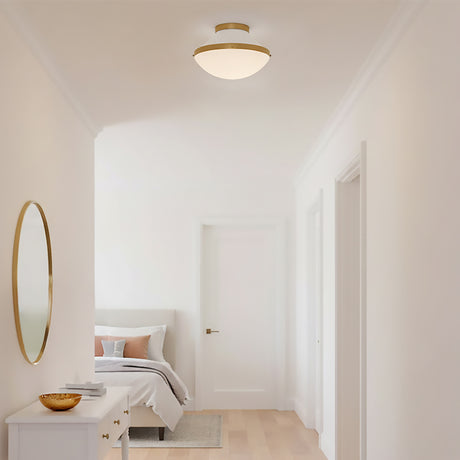 Blair Flush Mount 12, White and Brass - Flush mount ceiling light with brass accents and a white diffuser illuminates a modern hallway with a bed and dresser visible in the background.