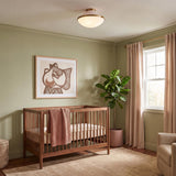 A mid-century modern bedroom with the Blair Flush Mount 16", Rose Quartz and Brass on the ceiling above a walnut wood crib and olive green walls.