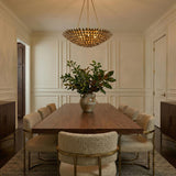 Alysa Chandelier, Antique Gold leaf design Chandelier in a Transitional Dining Room with a walnut dining table and bouclé chairs.