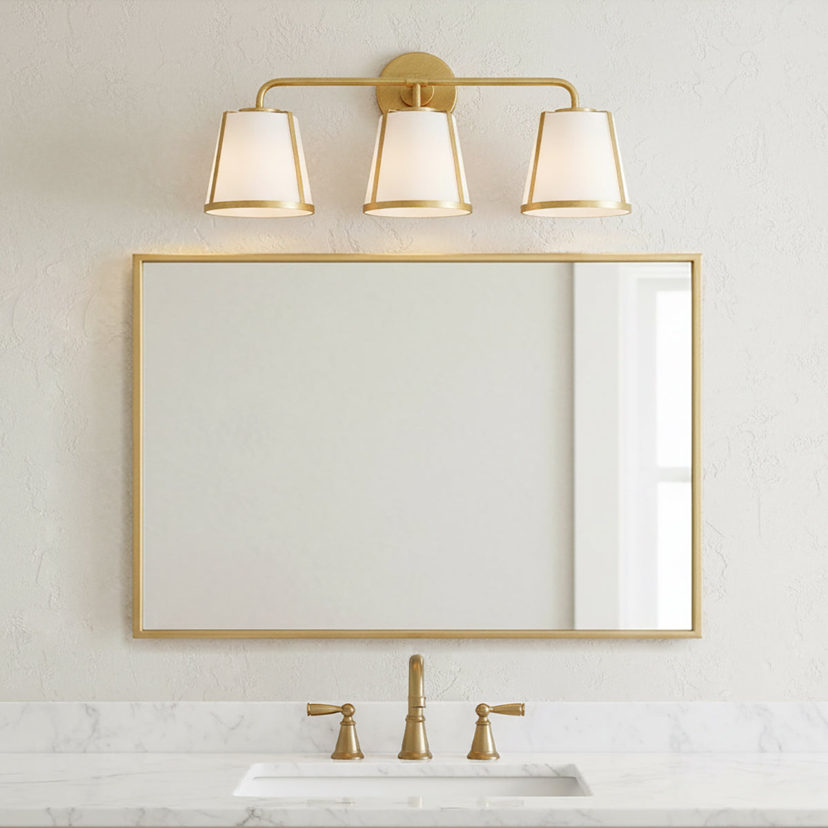 Hoyt 3 Light Vanity Light, Antique Gold with Opal Glass, shown above a single sink and mirror in a neutral decorated bathroom.