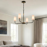 A transitional bedroom featuring a matte black and brushed brass chandelier with opal glass shades hung from a standard ceiling above a neutral upholstered bed.