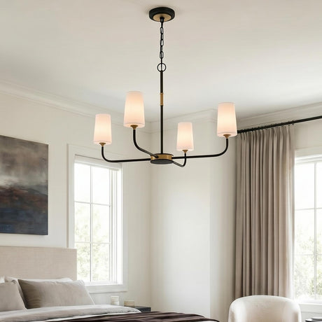 A transitional bedroom featuring a matte black and brushed brass chandelier with opal glass shades hung from a standard ceiling above a neutral upholstered bed.