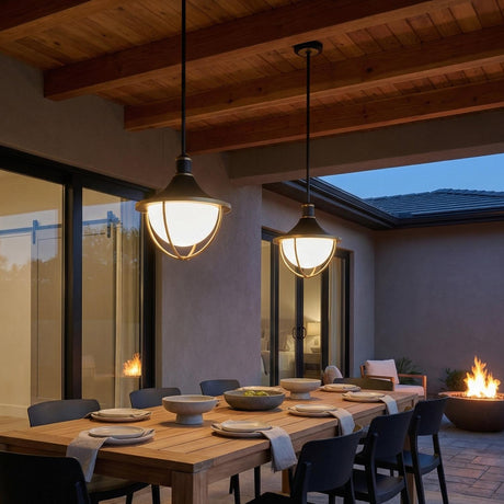 Tobin Outdoor Pendant Light 16", Black and Textured Gold globe Pendant in a Modern Outdoor with a rustic wood dining table and fire pit.