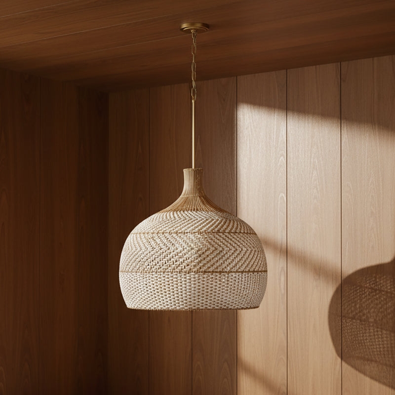 Sienna Extra Large Pendant 26, Rattan and Soft Brass - A woven pendant light hanging in a wood-paneled room