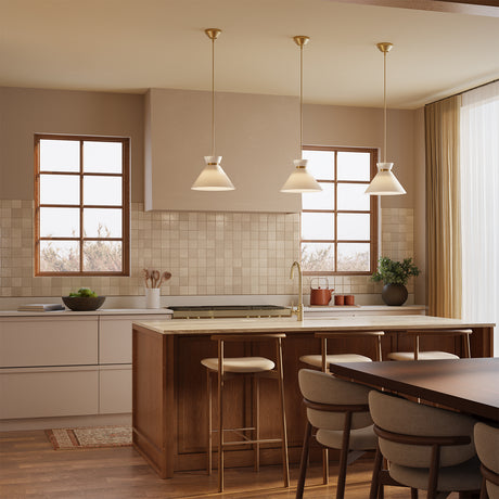 Three Cori Medium Pendant  lights in Brushed Brass and Milk Glass hung above a kitchen island in a taupe kitchen.