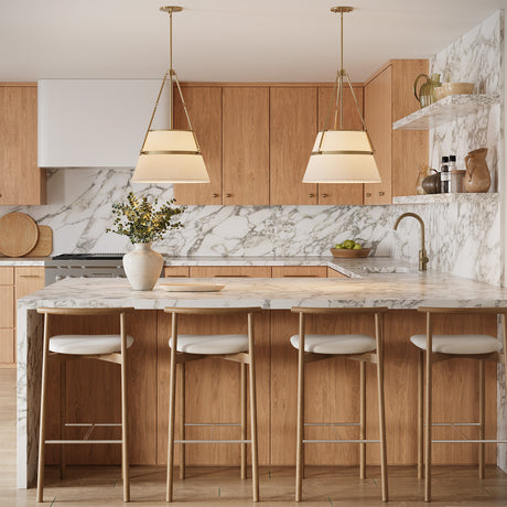 Two Julien 18" Pendants, in Antique Brass with white fabric conical shades, hung above a kitchen peninsula with marble countertops and white oak cabinetry