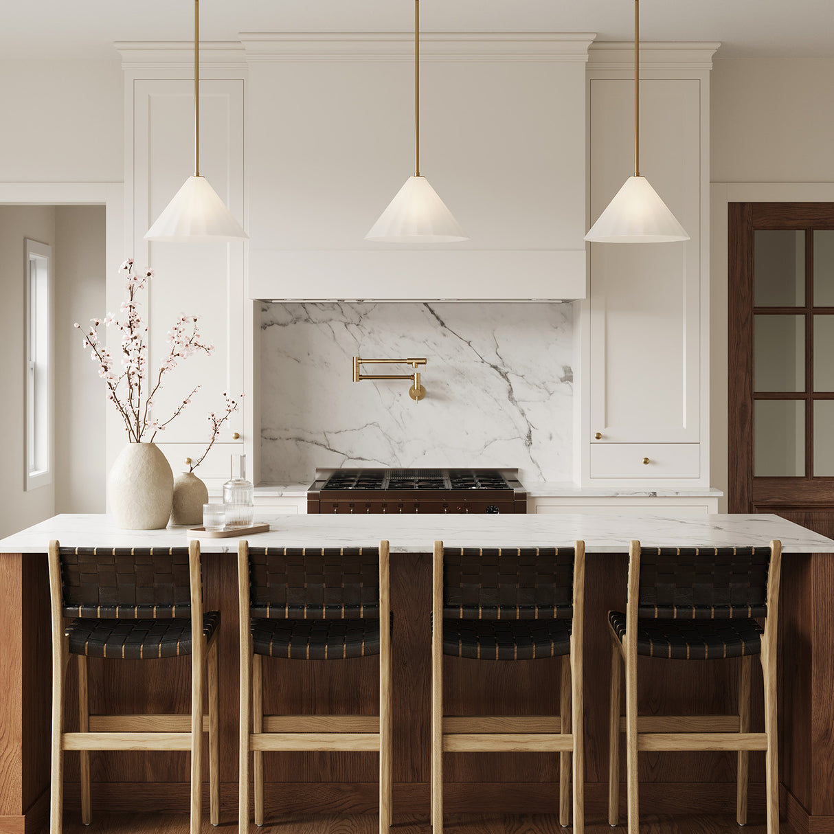 Three Reese 14" pleated opal glass pendant lights with brass details are shown in a modern farmhouse kitchen with cream and wood finishes.