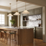 Three Reese Large 20" Pendant s, Aged Brass and Opal Glass, hung above a large kitchen island in a traditional upscale kitchen with sage green and wood cabinets and marble stone backplash