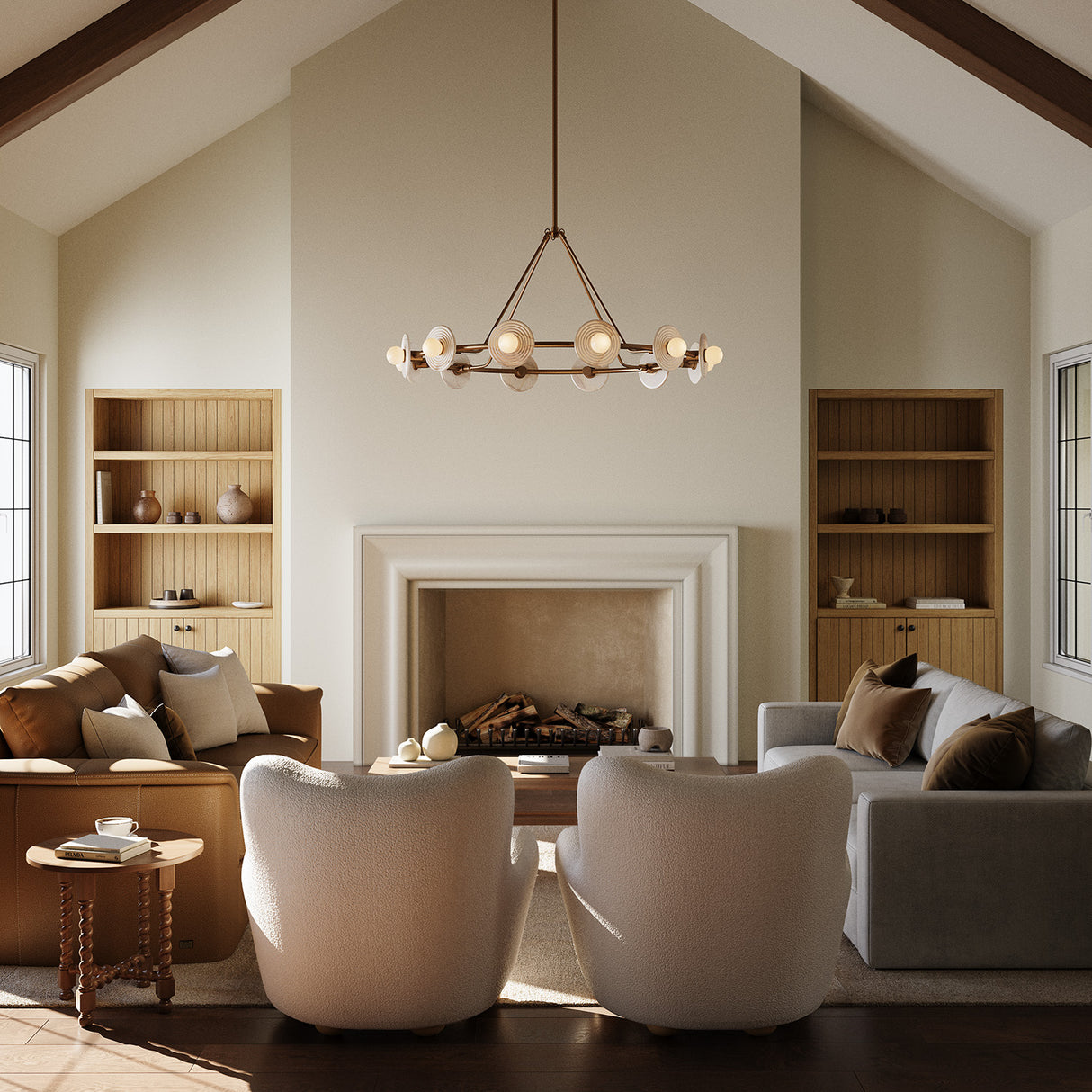 Bren round chandelier with ten globes and real alabaster stone disk, finished in vintage brass, is suspended in a large living rom with a vaulted ceiling and wooden beams, with warm sunlight streaming into the space.