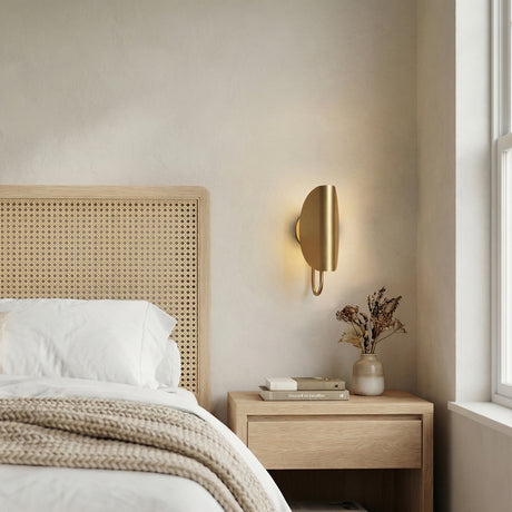 Nico Wall Sconce, Antique Brass styled in a Modern Bedroom with textured walls and wood furniture.