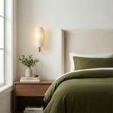 Nico Wall Sconce, Antique Brass with Fabric Shade styled in a Transitional Bedroom with natural wood.