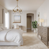 Elle Chandelier, Brushed Brass and Clear Glass, shown in a bright transitional contemporary bedroom.
