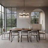 Elle Chandelier 26, Matte Black and Clear Glass - A modern dining room with a wooden table, chairs, and a chandelier hanging above.