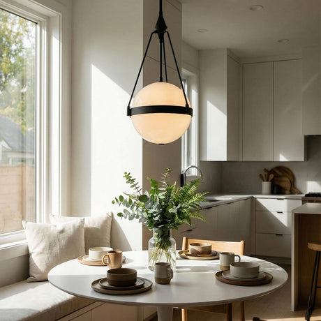 A modern kitchen breakfast nook featuring the Darcy Medium Pendant 14 inch in matte black and milk glass over a white circular table with neutral cabinetry.