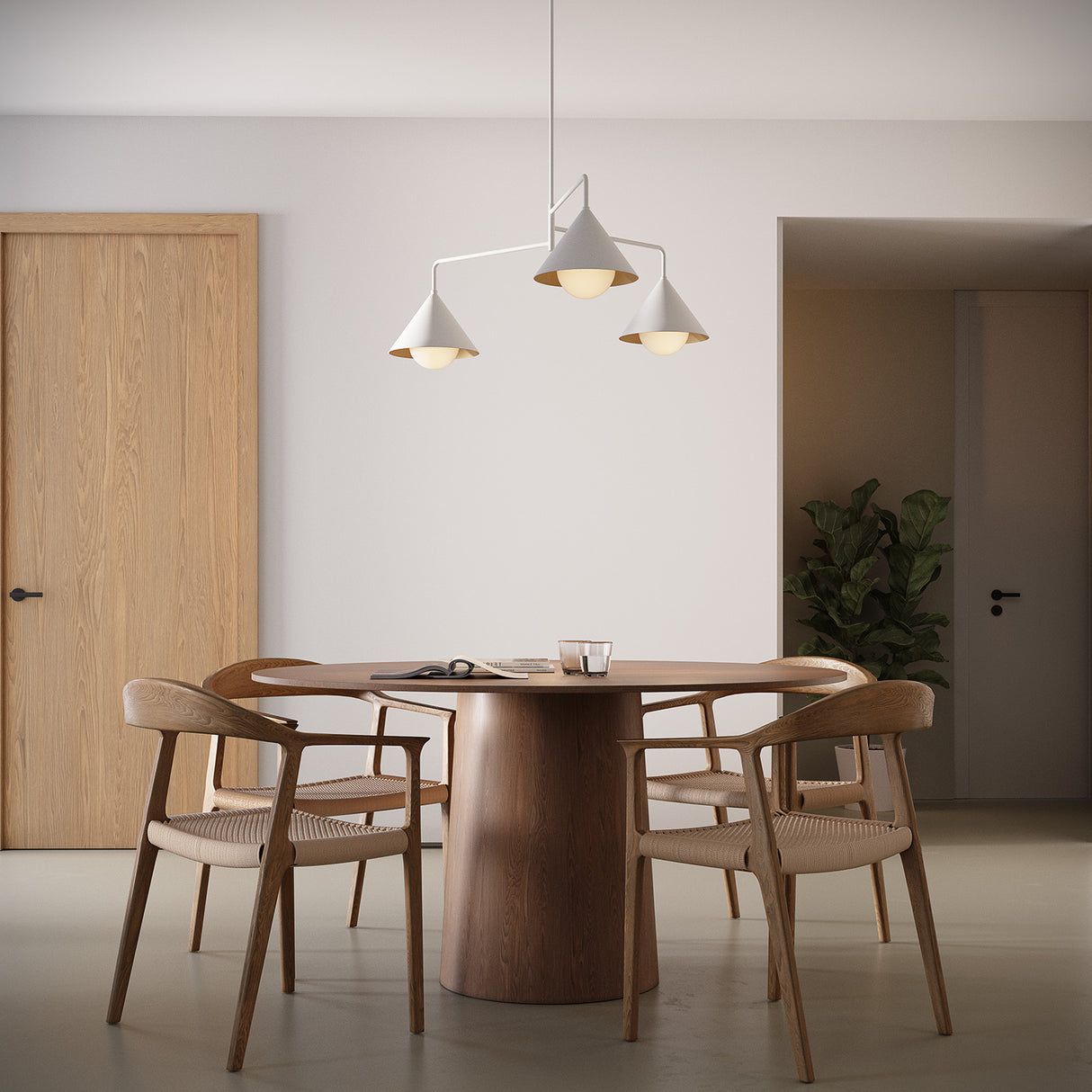 Juno 38" wide three light chandelier in white finish above a round modern dining table with four chairs.