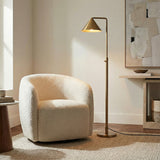 Brushed Brass geometric floor lamp in a Modern Living Room with a cream bouclé armchair.