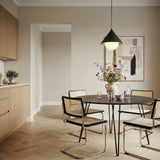Juno Pendant 14, Matte Black and Opal Glass, in a contemporary dining room with light wood cabinetry and herringbone flooring.