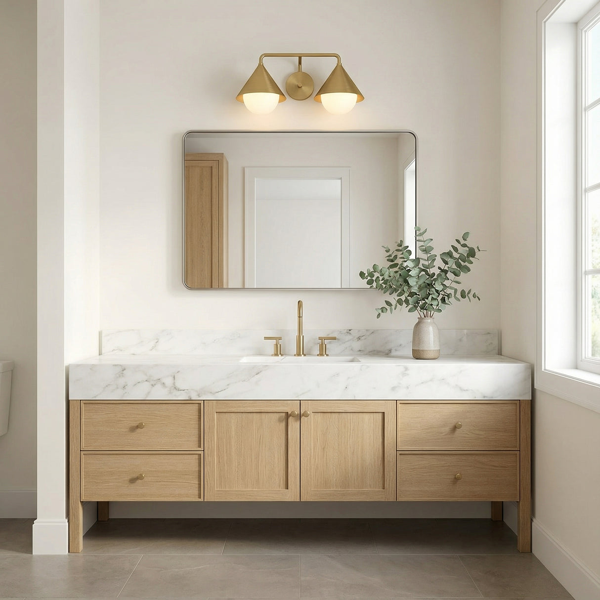 Brushed Brass and Opal Glass geometric vanity in a Modern Bathroom with a natural wood vanity and marble countertop.