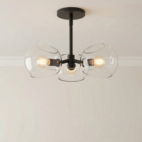 Flynn 3 Light Pendant 16", Matte Black with Clear Glass globe in a Modern Entryway with a simple light wall.